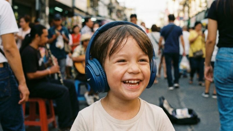 Child wearing safe volume limiting noise cancelling headphones in noisy airport.